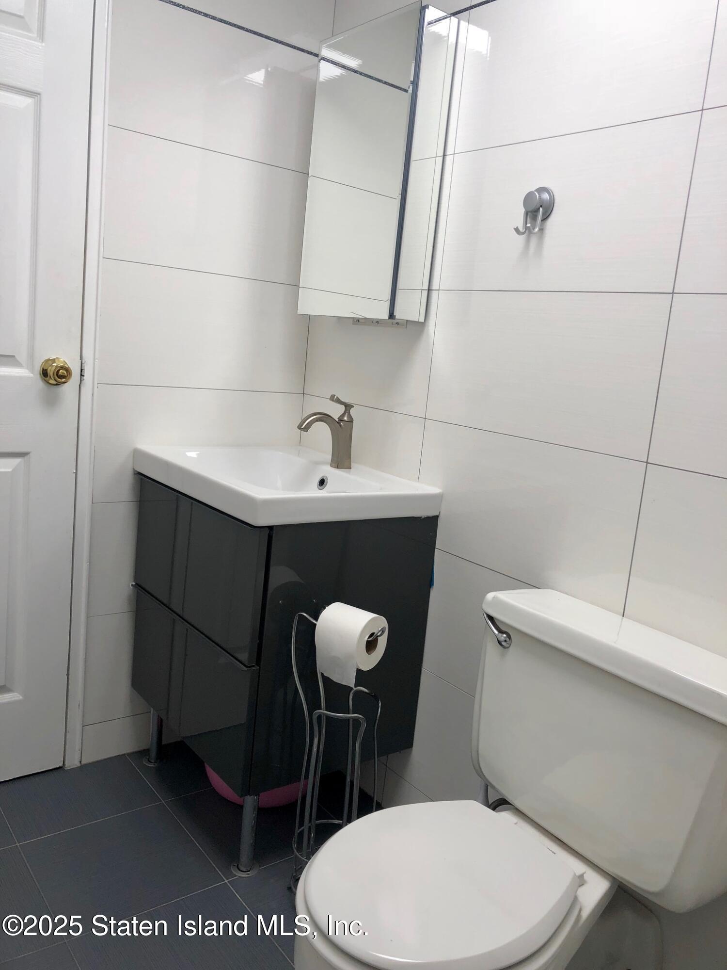 11 Windham Loop, Unit 2DD Staten Island, NY 10314 - Photo 8 of 27 a bathroom with a toilet a sink and mirror