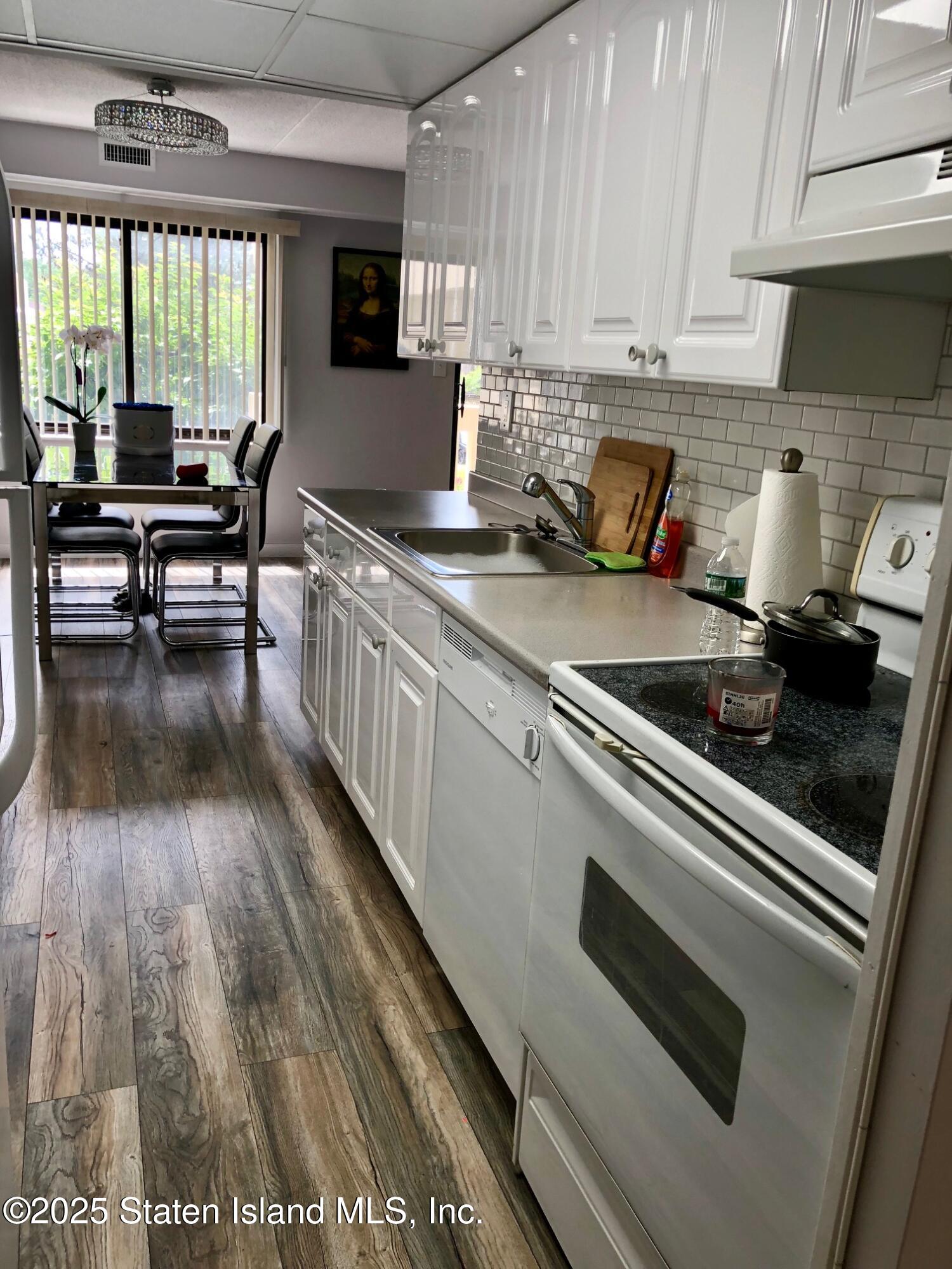 11 Windham Loop, Unit 2DD Staten Island, NY 10314 - Photo 9 of 27 a kitchen with a stove and white cabinets