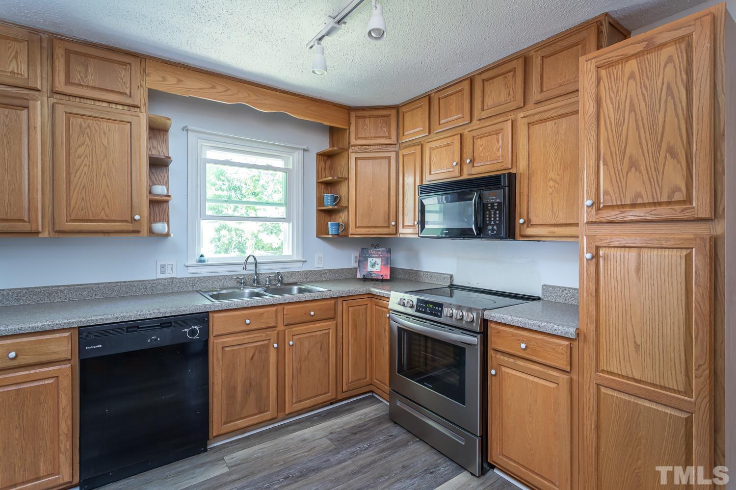 1304 Lake Pine Drive Cary, NC 27511 - Photo 14 of 26 a kitchen with stainless steel appliances granite countertop white cabinets granite counter tops and a window