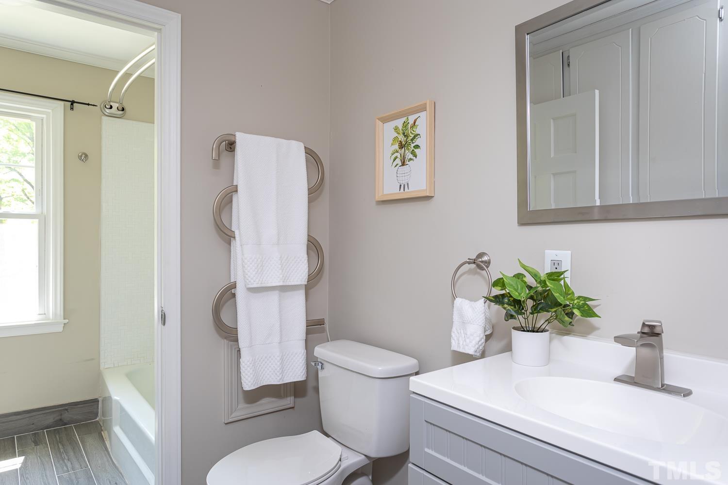 1304 Lake Pine Drive Cary, NC 27511 - Photo 18 of 26 a bathroom with a toilet a sink and a mirror
