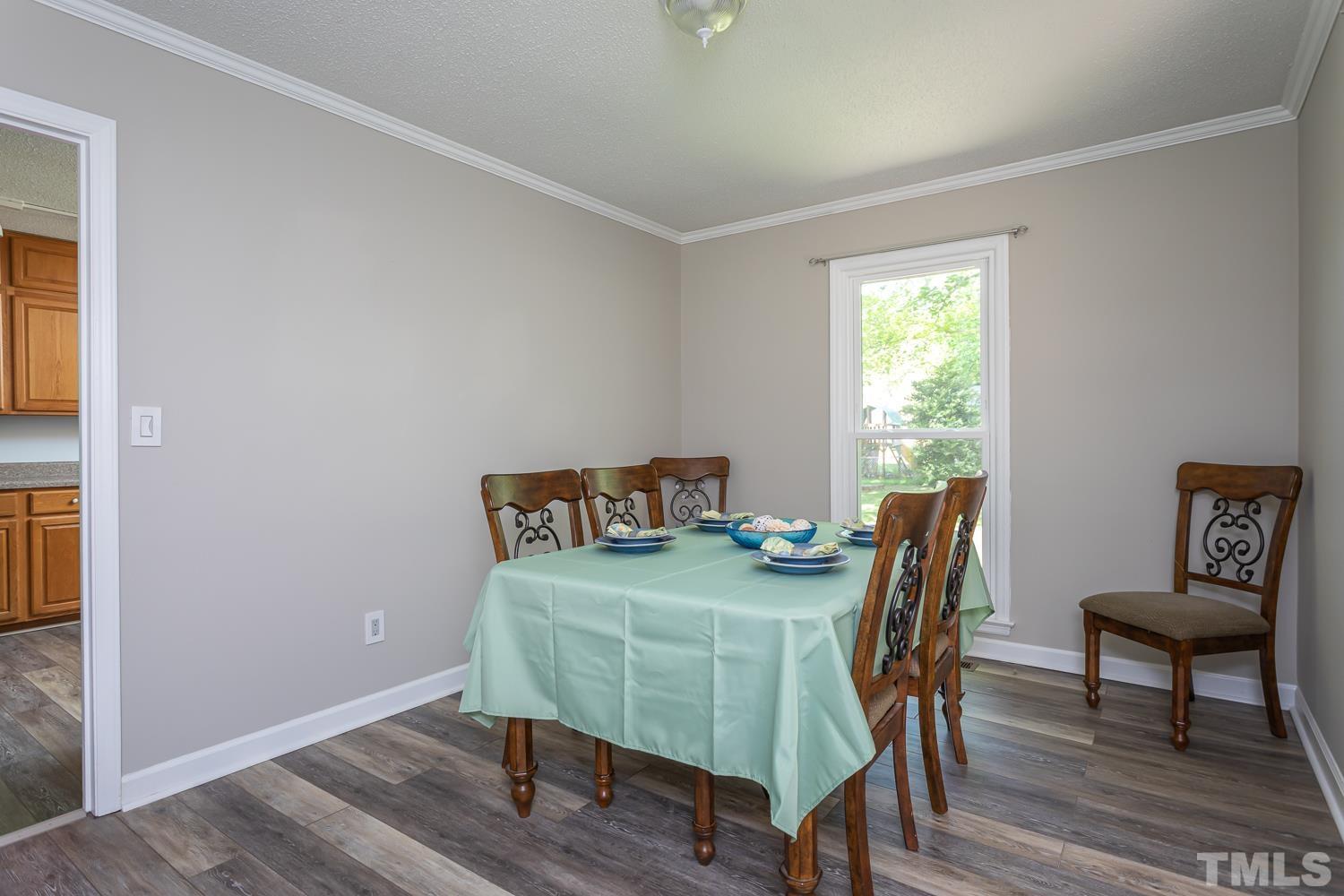 1304 Lake Pine Drive Cary, NC 27511 - Photo 8 of 26 a view of a dining room with furniture and wooden floor
