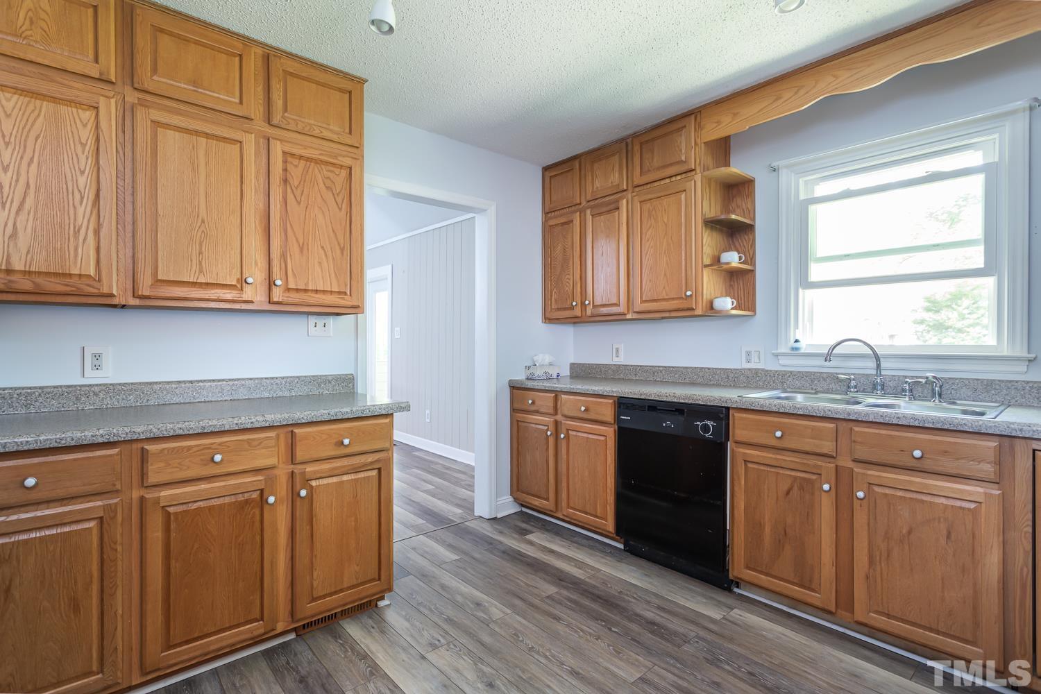 1304 Lake Pine Drive Cary, NC 27511 - Photo 9 of 26 a kitchen with granite countertop wooden cabinets a sink and dishwasher
