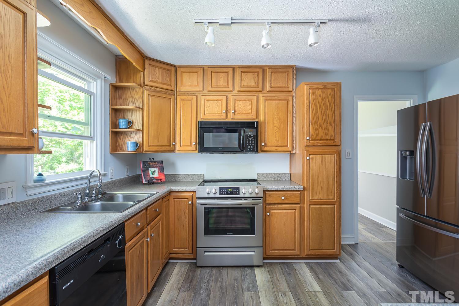1304 Lake Pine Drive Cary, NC 27511 - Photo 10 of 26 a kitchen with stainless steel appliances a stove a sink and a refrigerator