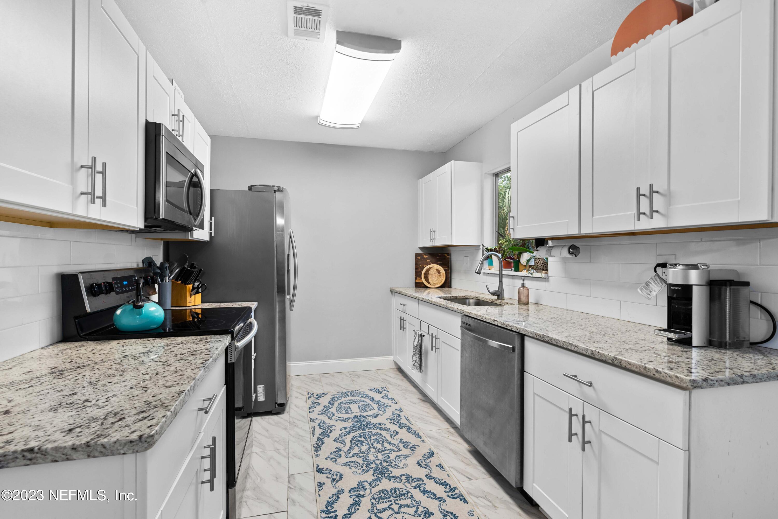 511 Gerona Road St. Augustine, FL 32086 - Photo 11 of 30 a kitchen with stainless steel appliances granite countertop a refrigerator sink and stove