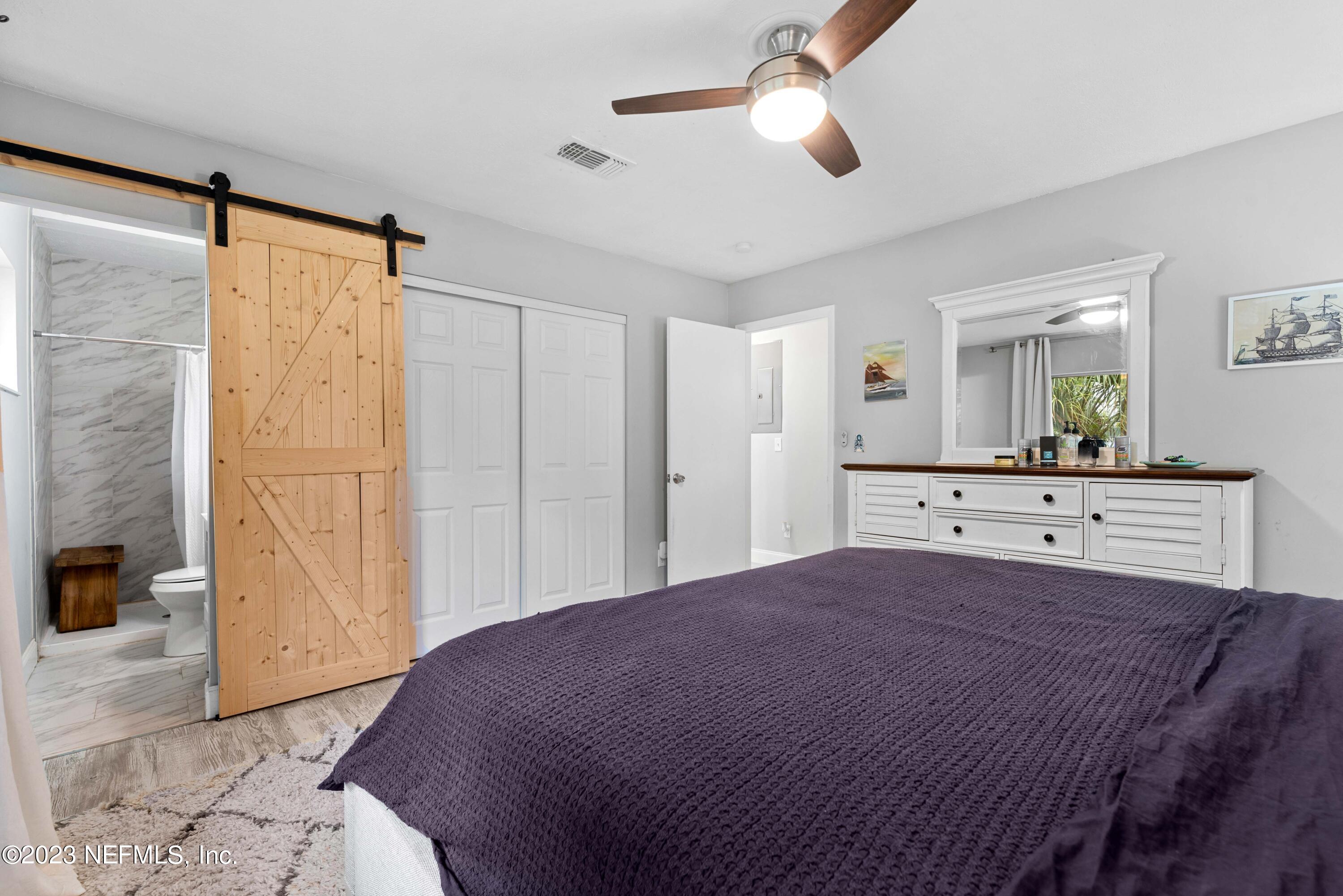 511 Gerona Road St. Augustine, FL 32086 - Photo 14 of 30 a bedroom with a large bed and a chandelier