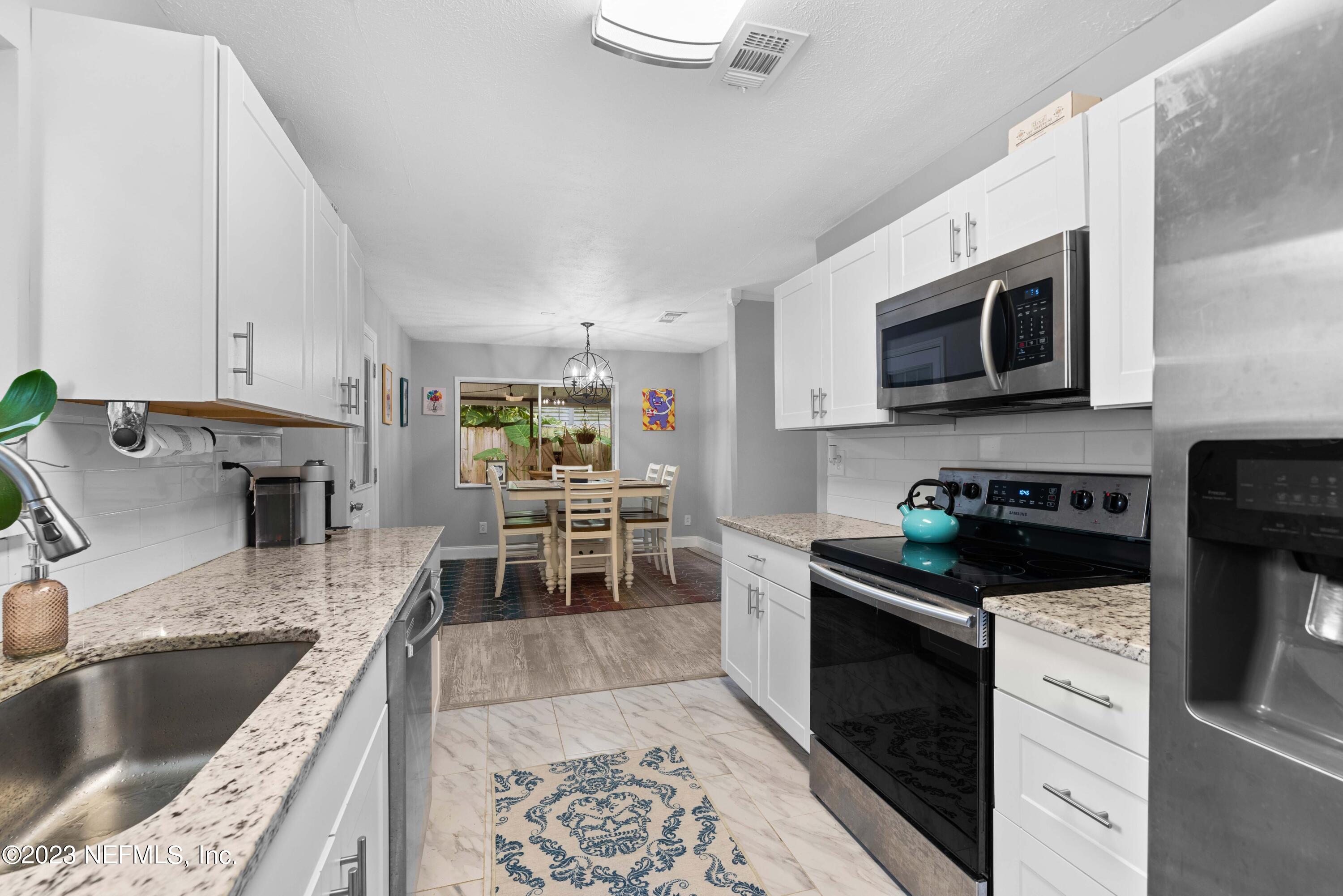 511 Gerona Road St. Augustine, FL 32086 - Photo 10 of 30 a kitchen with stainless steel appliances granite countertop a sink stove and microwave