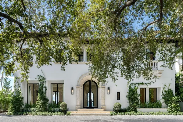 a front view of a house with a garden