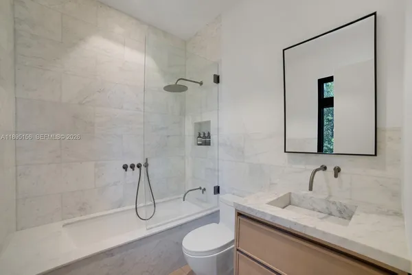 a utility room with dryer washer and a view of wooden floor