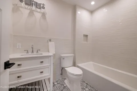 a bathroom with a granite countertop sink a toilet and shower