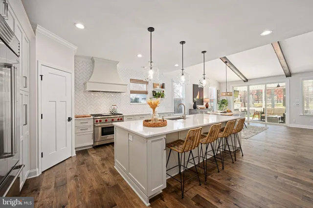 a kitchen with stainless steel appliances kitchen island wooden floors and white cabinets