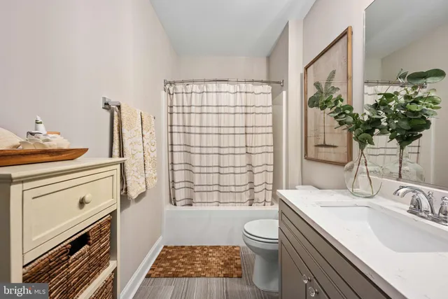 a bathroom with a sink a toilet a mirror and shower