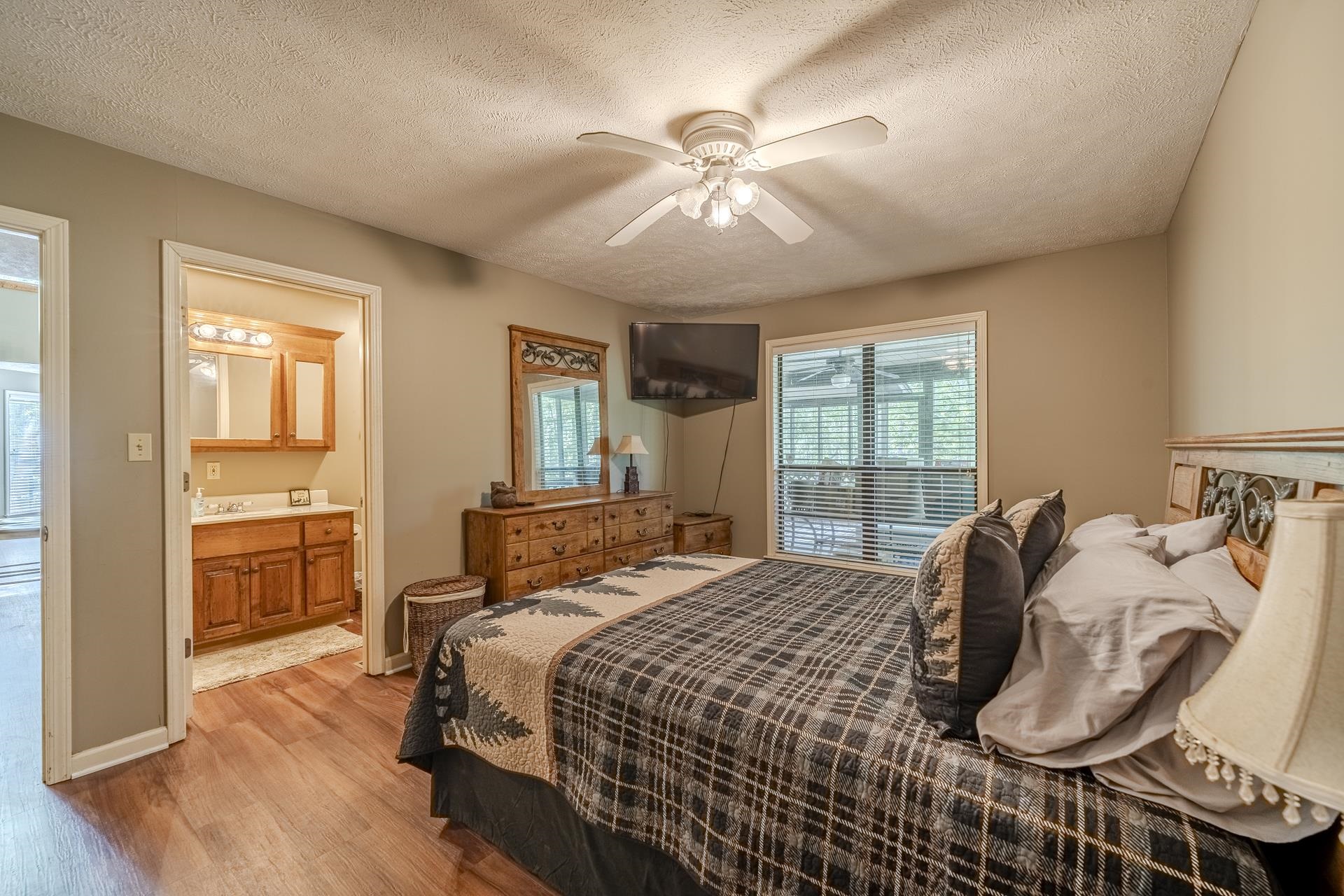 435 Murray Lane Counce, TN 38326 - Photo 16 of 34 Bedroom featuring wood-finish flooring, a ceiling fan with light fixture, and a large window with blinds