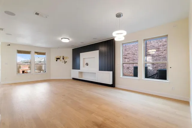 an empty room with windows and fireplace