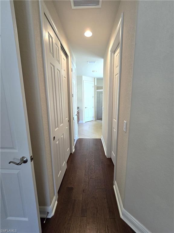 7887 Martino Circle Naples, FL 34112 - Photo 11 of 25 a view of a hallway with wooden floor and staircase