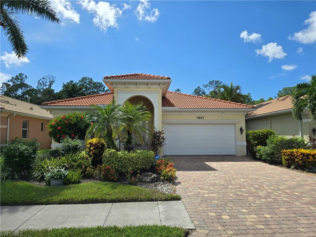7887 Martino Circle Naples, FL 34112 - Photo 2 of 25 a front view of a house with a garden