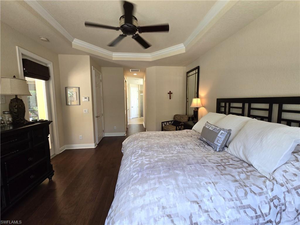 7887 Martino Circle Naples, FL 34112 - Photo 9 of 25 a bedroom with a bed and wooden floor