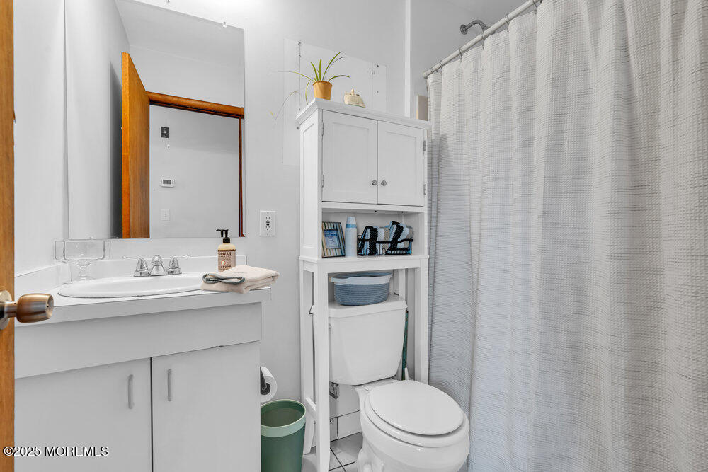 308 16th Avenue Belmar, NJ 07719 - Photo 38 of 54 a bathroom with a toilet a sink and a mirror