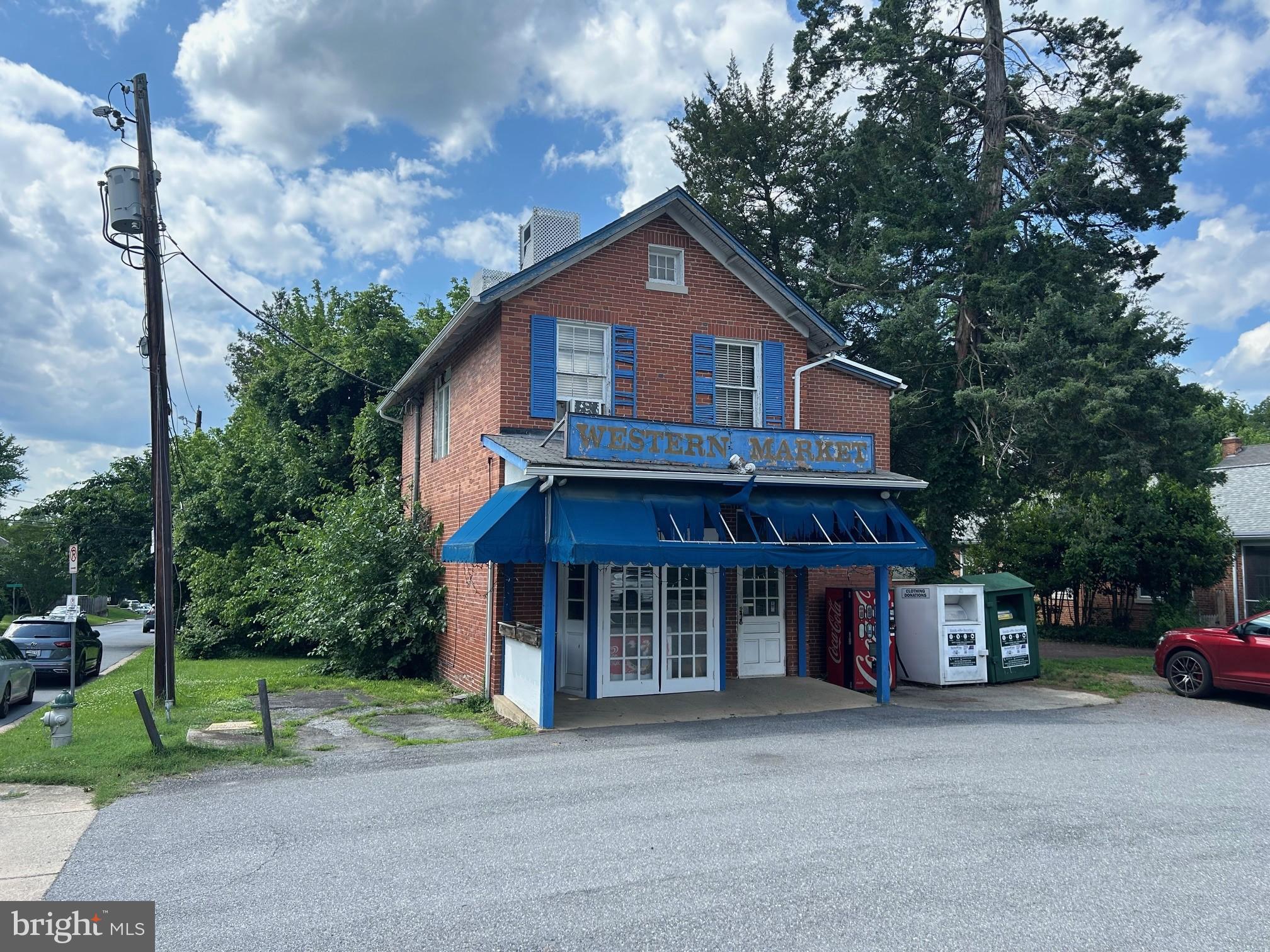 4840-4842 Western Avenue Northwest Bethesda, MD 20816 - Photo 1 of 5 Charming brick market with vibrant blue awning.
