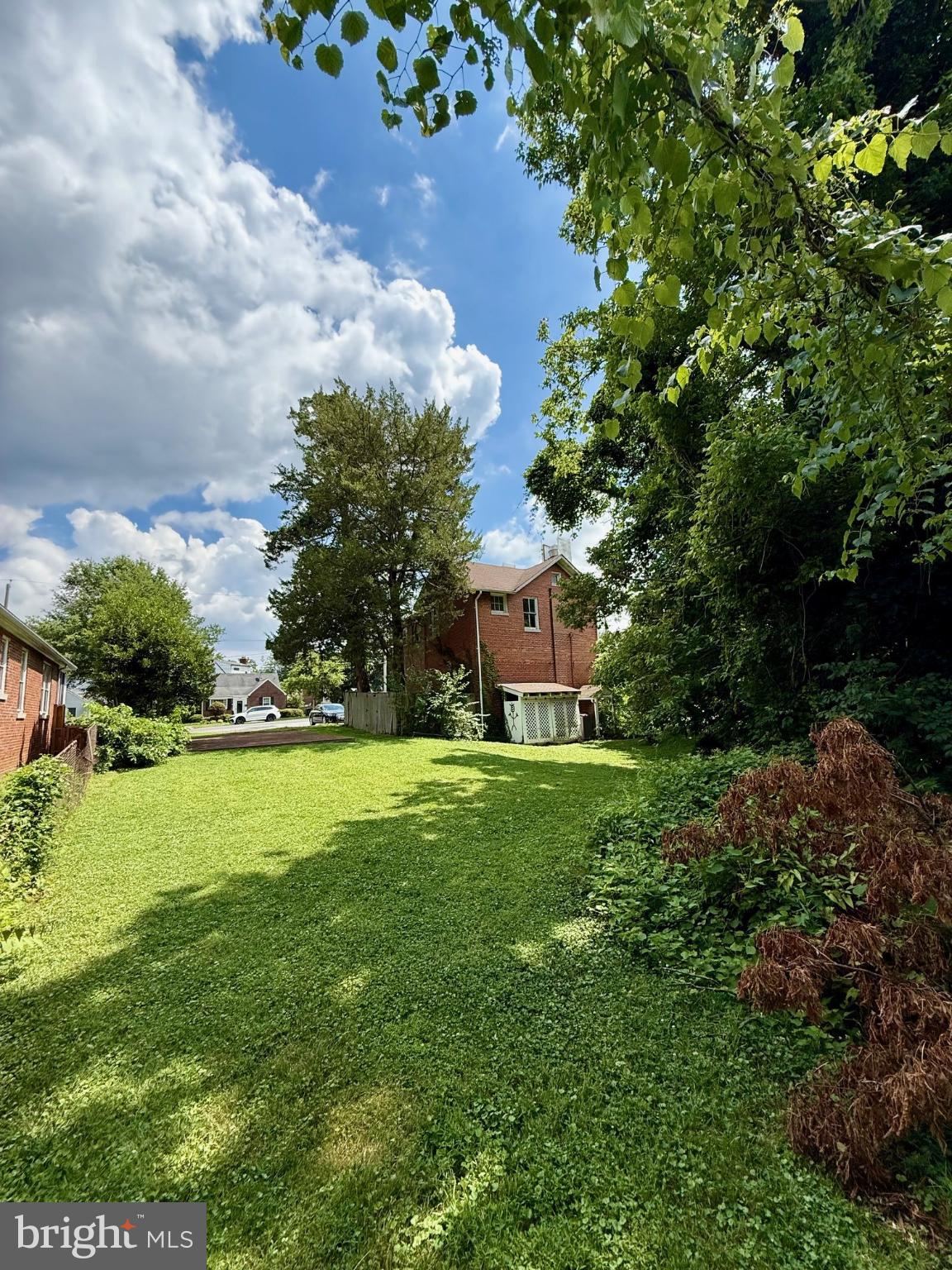 4840-4842 Western Avenue Northwest Bethesda, MD 20816 - Photo 2 of 5 Lush green yard under a bright blue sky.