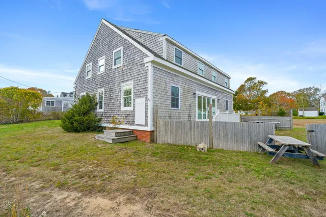 a backyard of a house with table and chairs