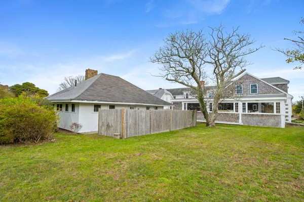 a view of a yard in front of a house with large trees