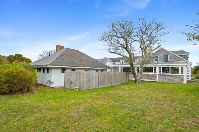 a view of a yard in front of a house with large trees