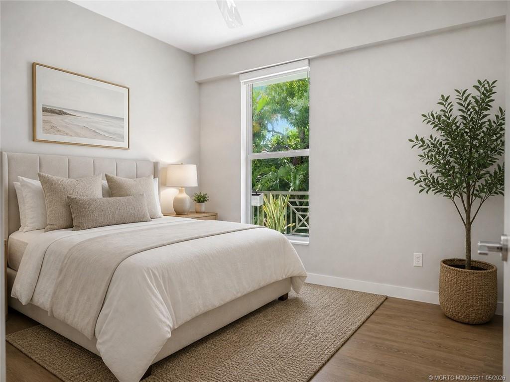 41 Southwest Seminole Street, Unit 208 Stuart, FL 34994 - Photo 30 of 46 a bedroom with a large bed and a potted plant