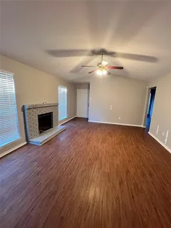 an empty room with wooden floor and fireplace