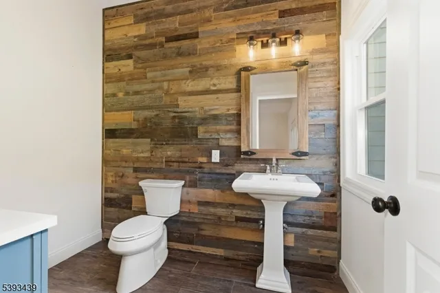 a bathroom with a sink a toilet and mirror