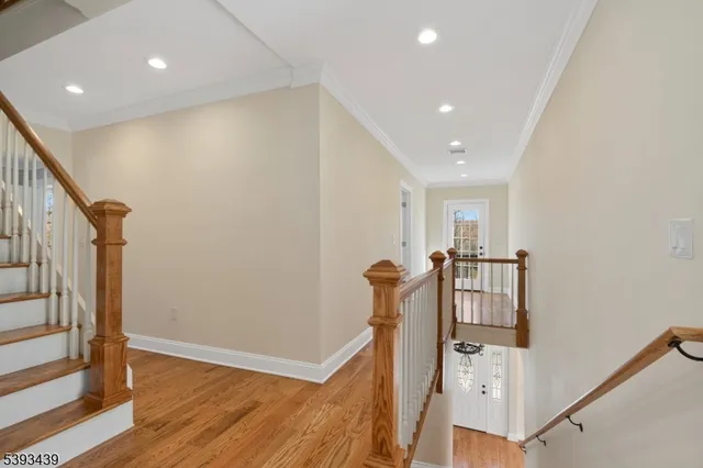 a view of a hallway with entryway and wooden floor