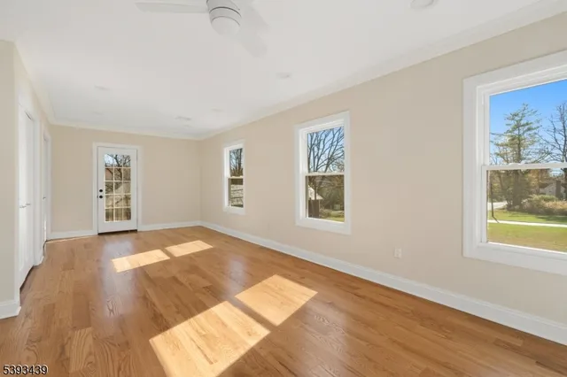 a view of a bedroom with wooden floor and a window