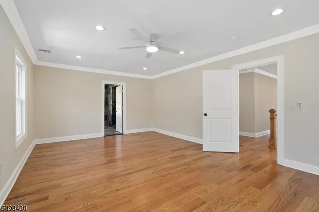 an empty room with wooden floor and natural light