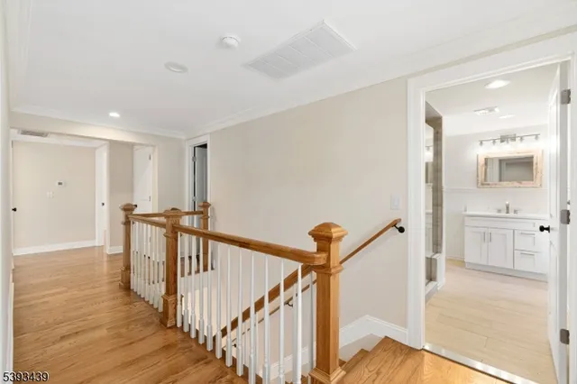 a view of a hallway with a hardwood floor and staircase
