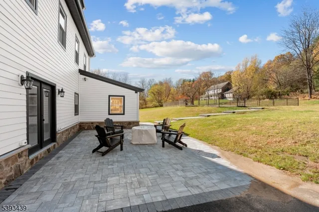 a view of swimming pool with lawn chairs and iron fence