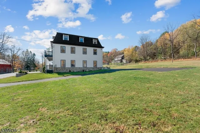 a large white house with a big yard and large trees