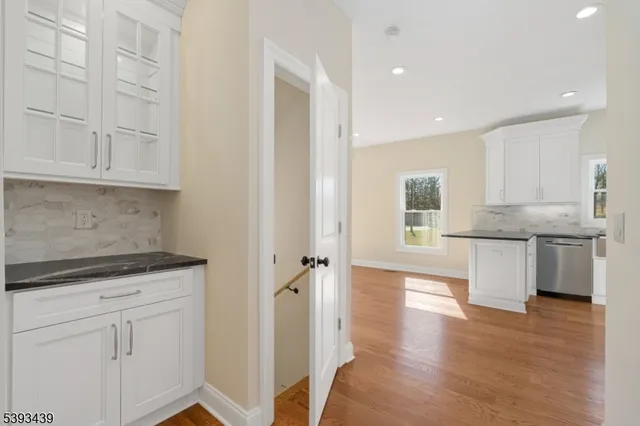 a kitchen with granite countertop white cabinets and white appliances