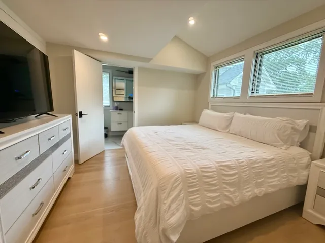 a spacious bedroom with a bed and a flat screen tv