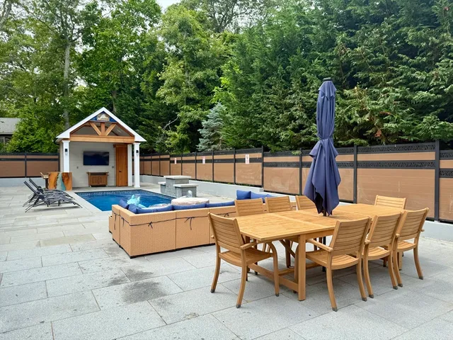 a patio with a table and chairs and a barbeque