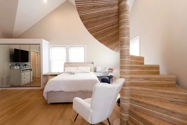 a bedroom with a bed and wooden floor