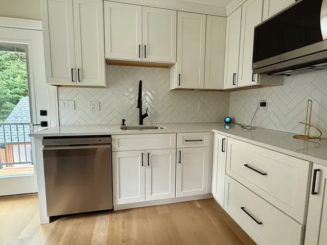 a kitchen with stainless steel appliances white cabinets and a sink