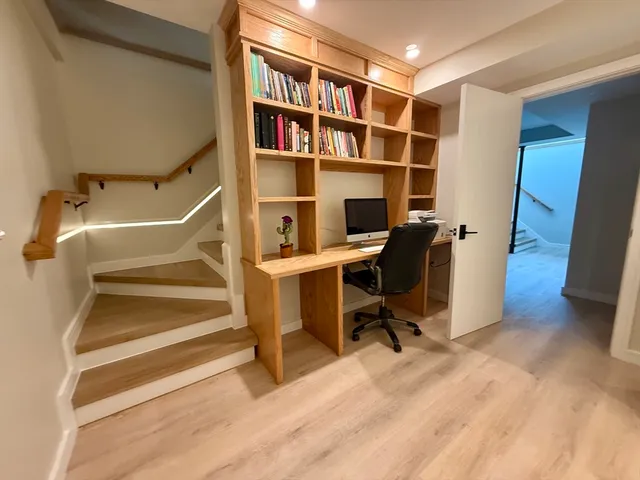 a view of a workspace with furniture and a window