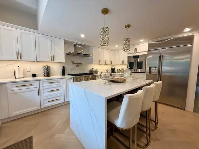 a kitchen with white cabinets and stainless steel appliances