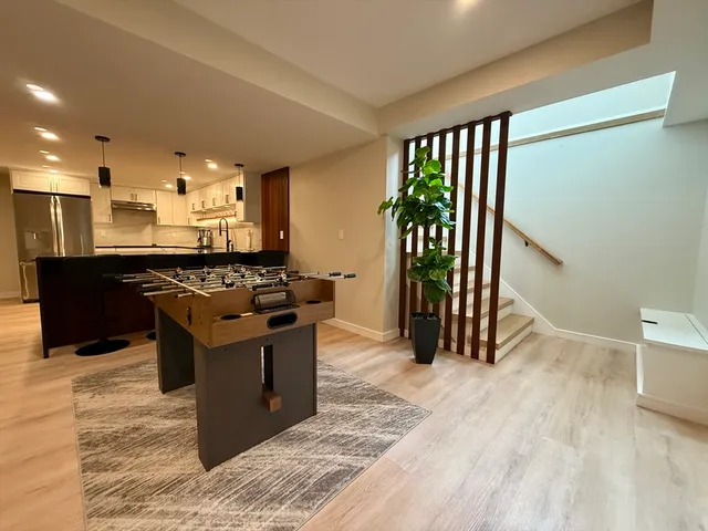 a kitchen with stainless steel appliances kitchen island granite countertop a refrigerator a sink dishwasher a stove and a refrigerator