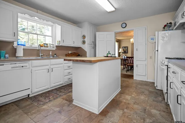 a kitchen with white cabinets and white appliances