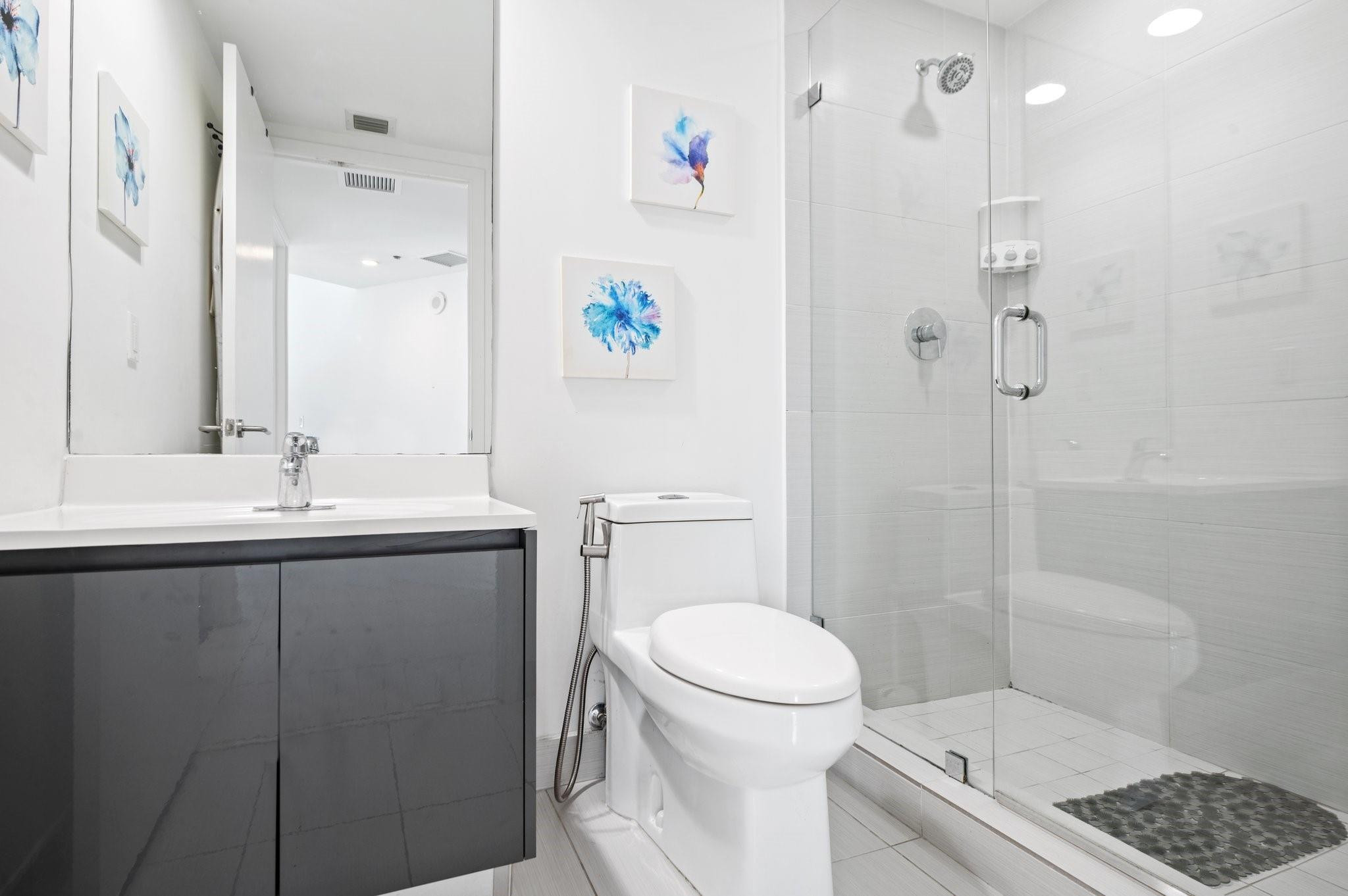 31 Southeast 6th Street, Unit 2002 Miami, FL 33131 - Photo 10 of 24 a bathroom with a sink a toilet and shower