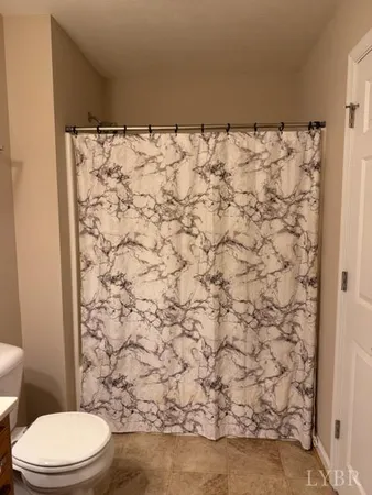 a bathroom with a toilet and a shower curtain