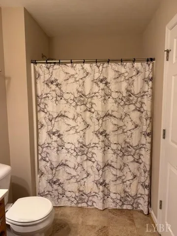 a bathroom with a toilet and a shower curtain