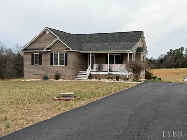 a front view of house with yard and trees in the background