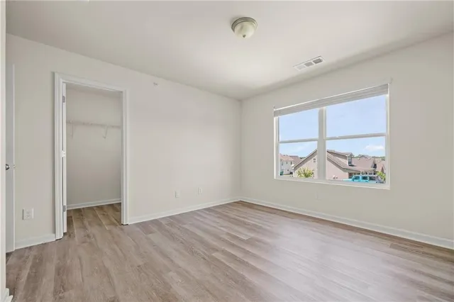 an empty room with wooden floor and window