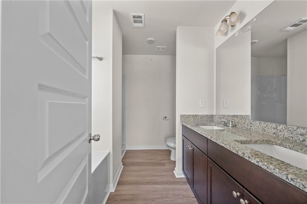 631 Carlton Pointe Drive, Unit 24 Palmetto, GA 30268 - Photo 18 of 20 a bathroom with a granite countertop sink a mirror and a shower